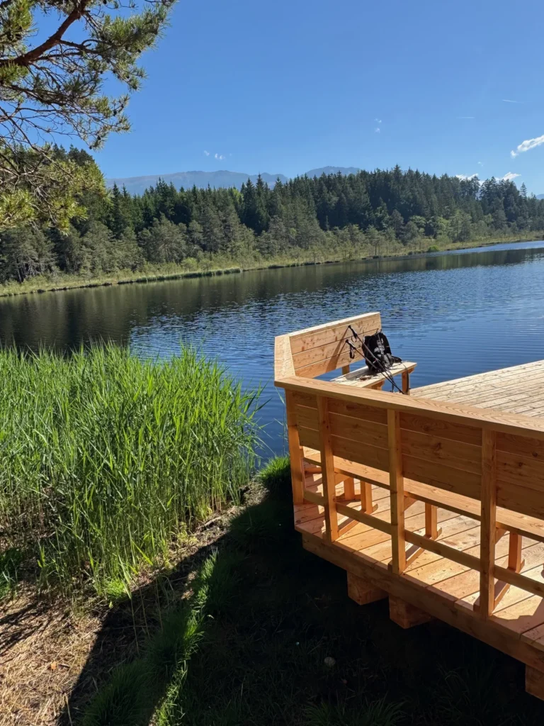 Ruhiger See mit Holzsteg als Bild zum Wandern
